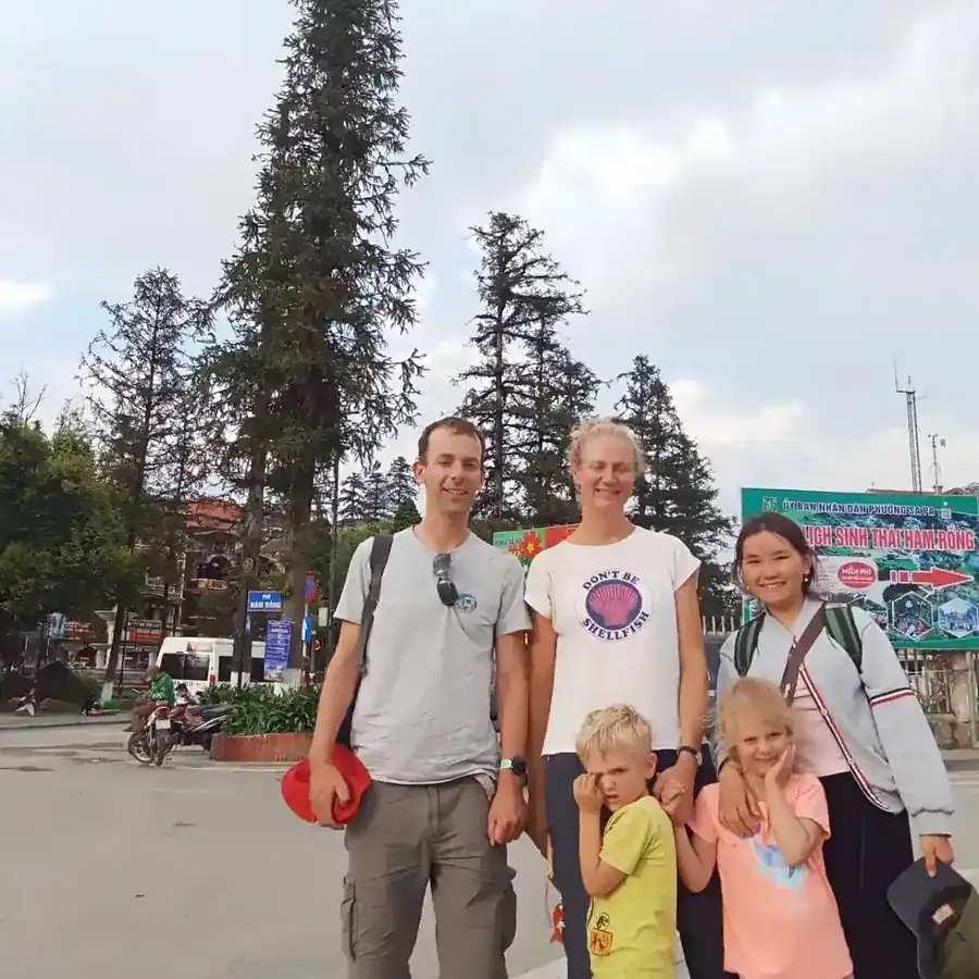 Australian family with two young children posing with their local Sapa guide in the town square during a family-friendly trekking tour